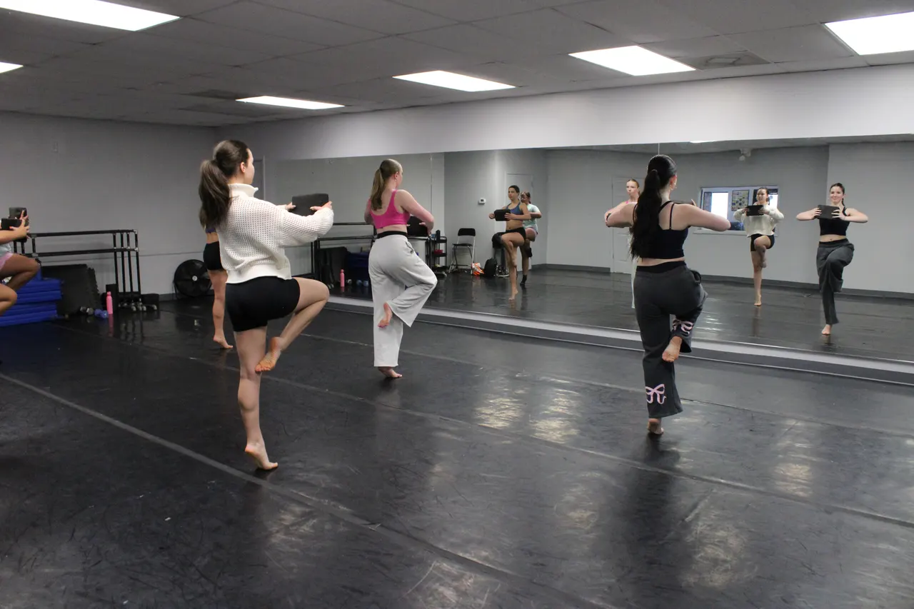 A class rehearsing in front of the studio mirror