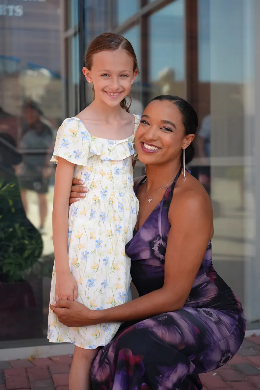 A young dancer smiling with an older dancer